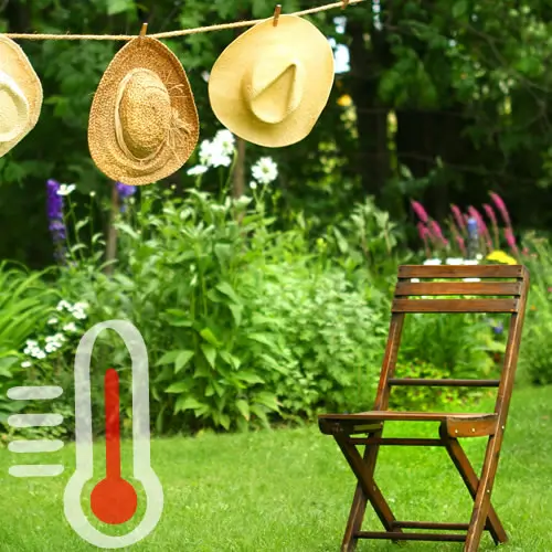Jardin avec chaise en bois et chapeaux de paille pendus dur un fil