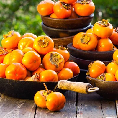 Kakis fruits oranges bols poêles table en bois Récolte