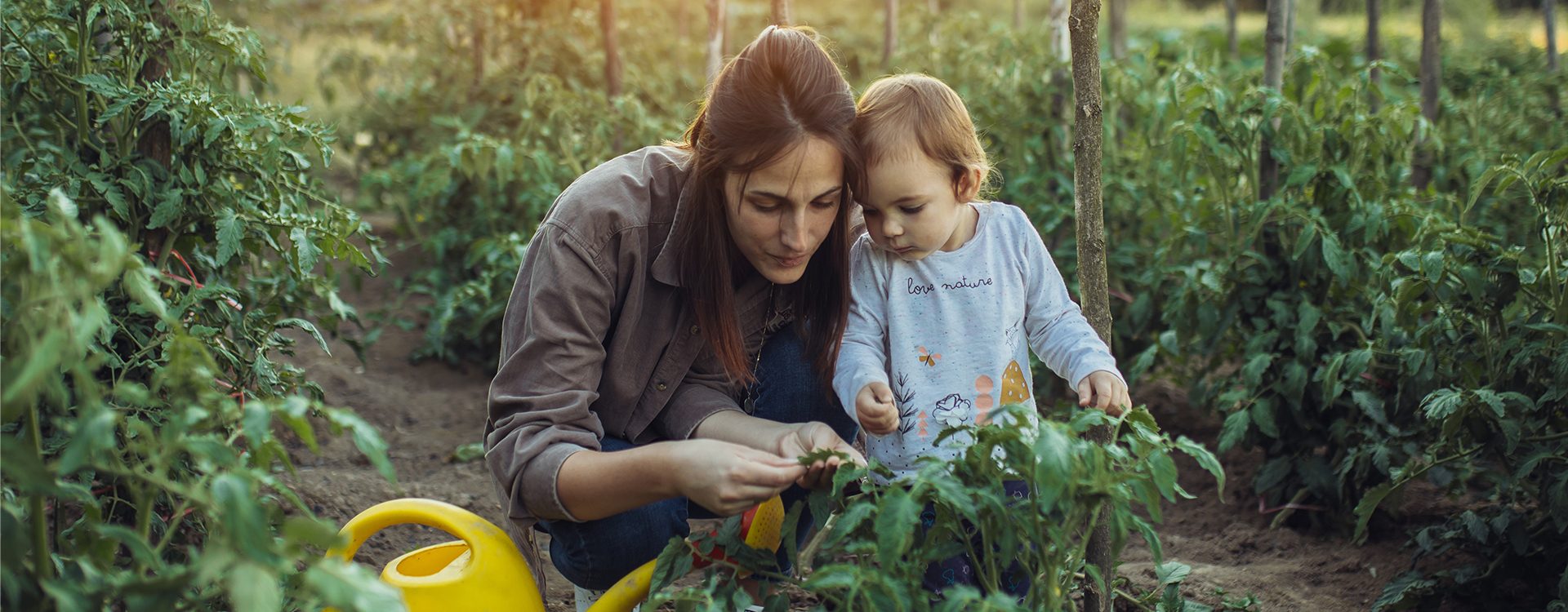 Une-mère-et-sa-fille-au-jardin-découvrent-une-plante