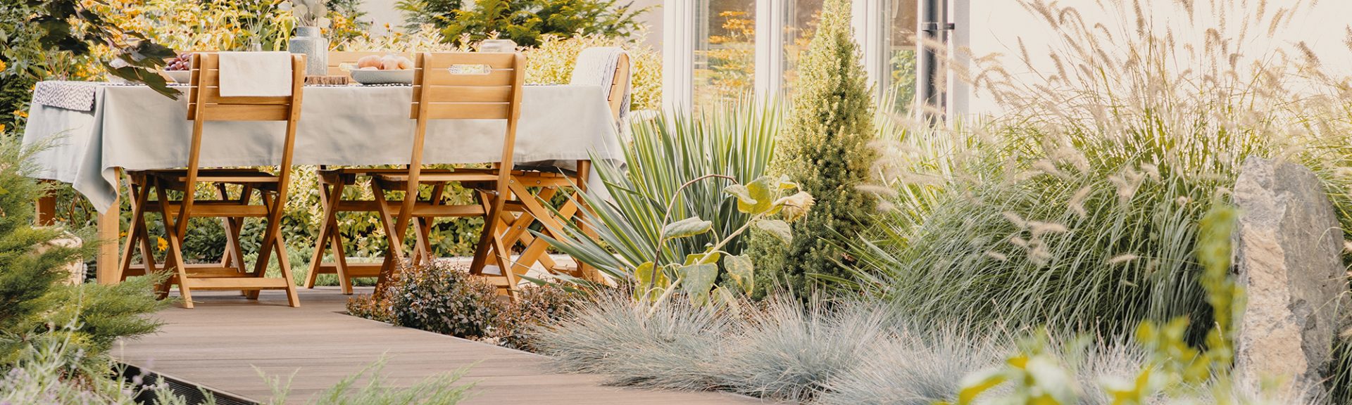 Plantes et chaises en bois à table avec de la nourriture sur la terrasse de la maison en été